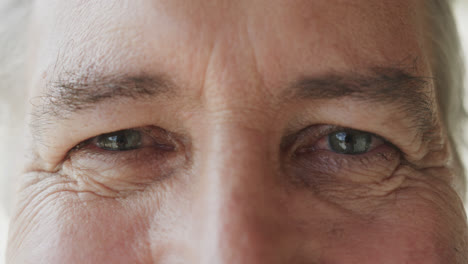 Portrait-close-up-of-the-eyes-of-smiling-senior-caucasian-man,-in-slow-motion