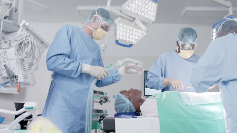 Focused-diverse-male-and-female-surgeons-with-face-masks-during-surgery-in-slow-motion,-unaltered