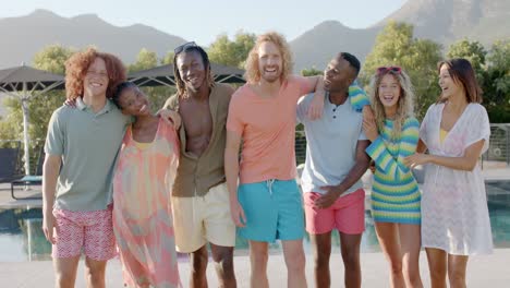 Portrait-of-happy-diverse-friends-standing-with-arms-around-at-sunny-pool-party,-slow-motion
