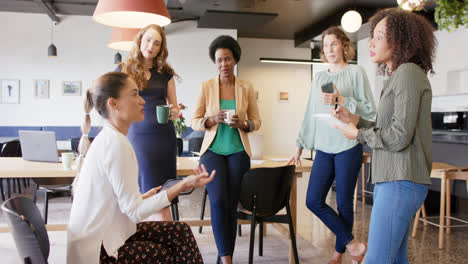 Verschiedene-Geschäftsfrauen-Treffen-Sich-In-Zeitlupe-Im-Büro,-Unterhalten-Sich-Und-Nutzen-Ein-Tablet