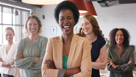 Portrait-of-happy-diverse-businesswomen-standing-in-office-with-arms-crossed-smiling,-in-slow-motion