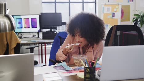African-american-female-designer-using-smartphone-during-lunch-in-casual-office,-slow-motion