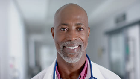 Portrait-of-happy-african-american-male-doctor-looking-at-camera-and-smiling,-slow-motion