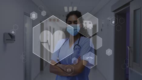 Animation-Medizinischer-Symbole-Und-Datenverarbeitung-über-Einer-Biracial-Ärztin-Mit-Gesichtsmaske