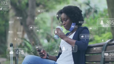 Animation-Von-Social-Media-Symbolen-über-Einer-Afroamerikanischen-Frau,-Die-Ihr-Smartphone-Benutzt-Und-Auf-Der-Bank-Sitzt