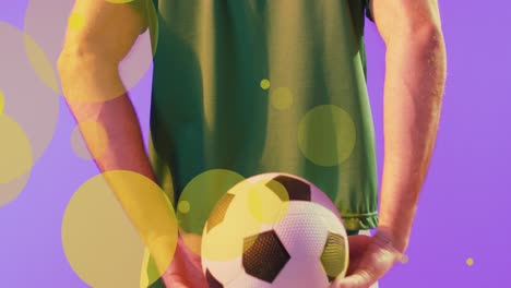 Animation-of-lens-flares-over-midsection-of-caucasian-player-hiding-soccer-ball