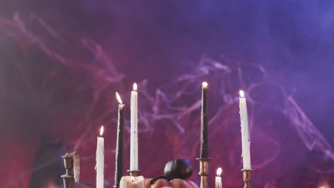 Video-of-halloween-skull,-candles-and-smoke-with-copy-space-on-purple-background