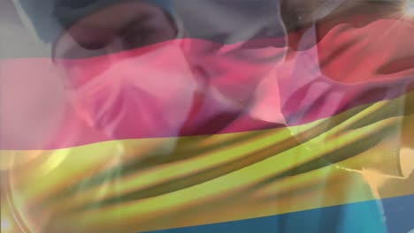 Animation-of-germany-flag-against-diverse-male-and-female-surgeon-performing-operation-at-hospital