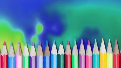 Animation-of-row-of-multi-coloured-pencils-over-blue-and-green-background