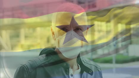 Animation-of-waving-ghana-flag-over-portrait-of-caucasian-man-wearing-face-mask-on-the-street