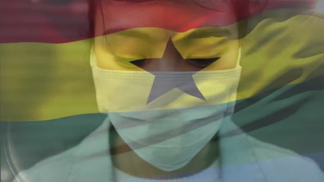 Animation-of-waving-ghana-flag-against-portrait-of-asian-woman-wearing-face-mask-on-the-street