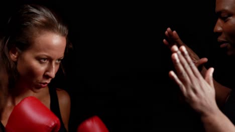Female-boxer-hitting-on-trainer-hand