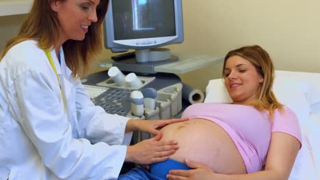 Doctor-pressing-hands-on-a-pregnant-womans-stomach