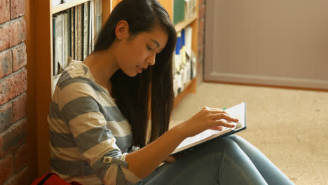 Student-reading-a-book-in-the-library