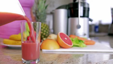 Woman-pouring-fresh-fruit-and-vegetable-juice