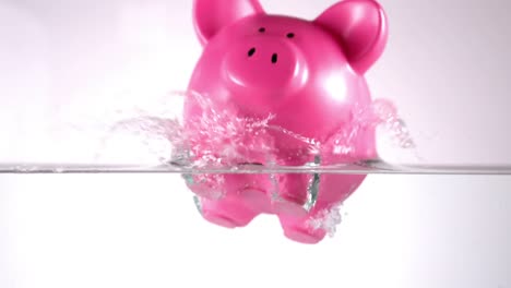Pink-piggy-bank-falling-in-water