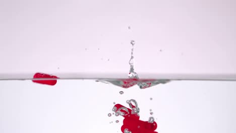 Lot-of-red-medication-falling-in-water