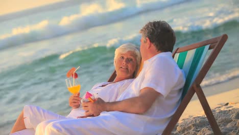 Elderly-couple-drinking-cocktails-on-the-beach