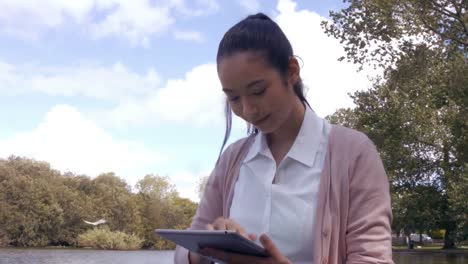 Businesswoman-using-tablet-in-the-park