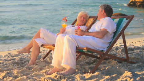 Mature-couple-talking-sitting-in-deckchairs