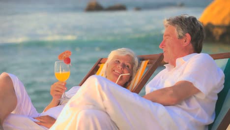 Mature-couple-drinking-cocktails-on-the-beach