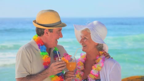 Couple-drinking-cocktails-on-a-beach