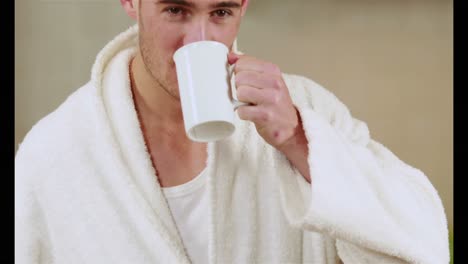 Handsome-man-drinking-coffee-in-bath-robe