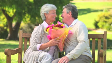 Mature-man-giving-a-bunch-of-flowers-to-his-wife-