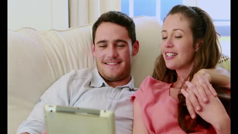 Cute-couple-using-tablet-pc-on-the-couch