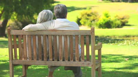 Mature-couple-sitting-talking-outdoors