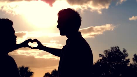 Silhouette-of-homosexual-couple-doing-heart-with-hands-together