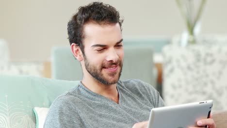 Happy-young-man-using-his-tablet