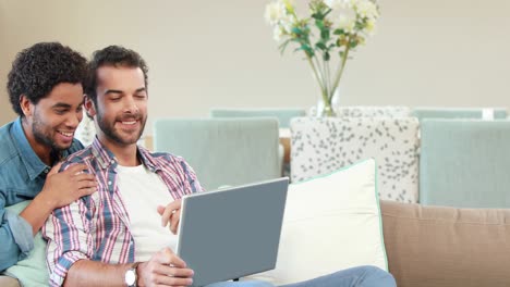 Gay-couple-relaxing-on-the-couch-using-laptop