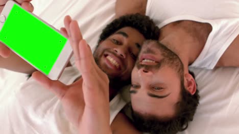 Gay-couple-relaxing-on-the-bed-taking-selfie