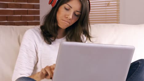 Mujer-Preocupada-Usando-Laptop-En-El-Sofá