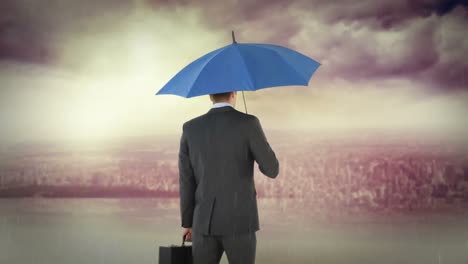 rear-view-of-businessman-holding-umbrella