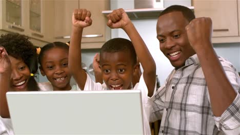Happy-black-family-rejoicing-and-using-laptop