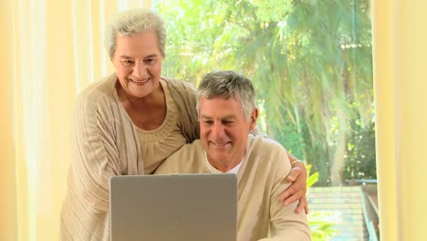 Mature-couple-smiling-about-something-on-a-laptop