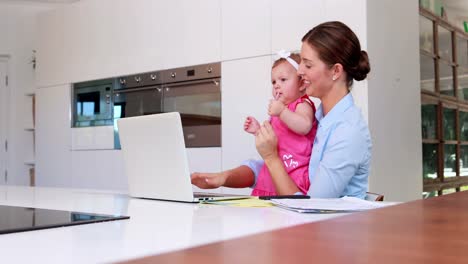 Businesswoman-with-her-baby-using-laptop