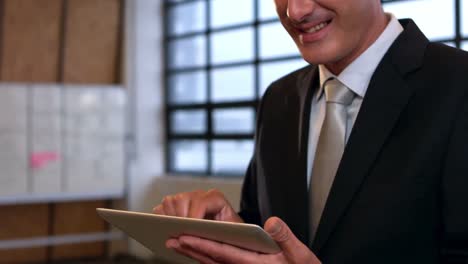Smiling-businessman-using-tablet