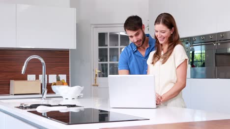 Glückliches-Paar,-Das-Laptop-In-Der-Küche-Benutzt