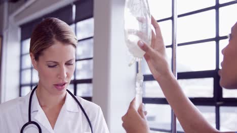 Doctor-and-nurse-examining-intravenous-drip-