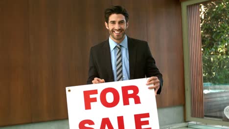 Happy-real-estate-agent-with-sold-sign