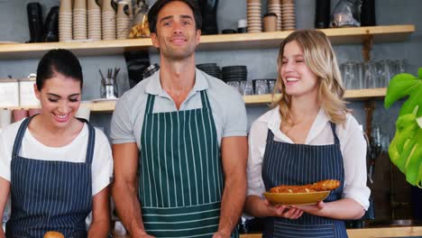 Portrait-of-happy-waiters-are-holding-pastries-and-posing