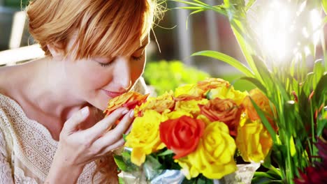 Beautiful-female-florist-smelling-roses