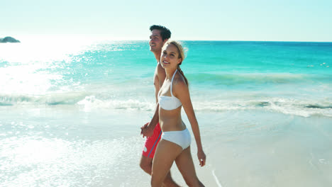 Couple-holding-hands-while-walking-on-the-beach