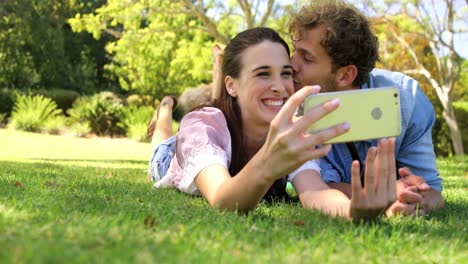 A-couple-lying-on-the-grass-taking-a-selfie-