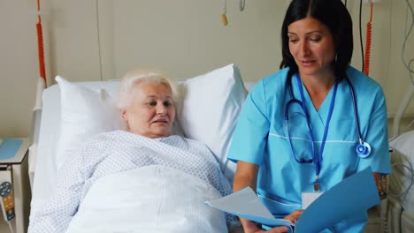 Ärztin-Bespricht-Bericht-Mit-älterem-Patienten