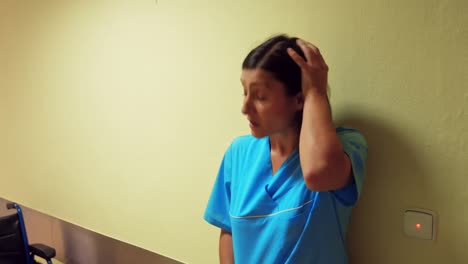 Depressed-nurse-leaning-in-corridor