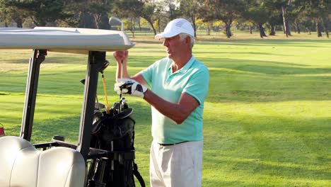 Male-golfer-removing-golf-club-from-golf-bag-